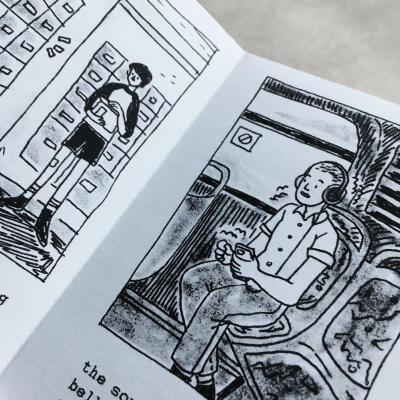 a photo of a black and white comic style zine being held